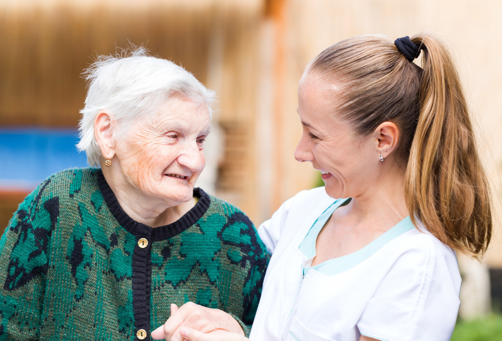 elderly woman with caregiver smiling 